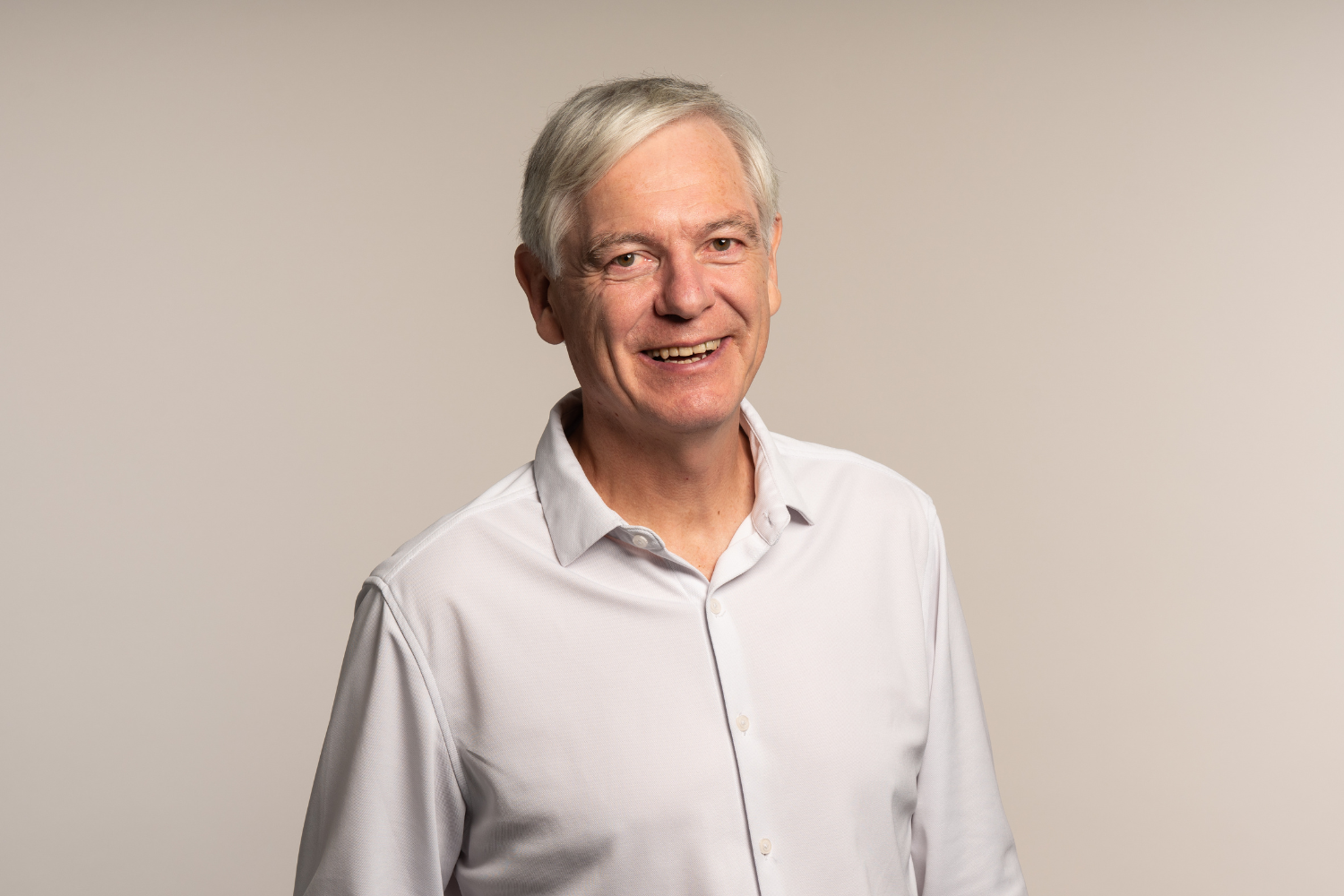 Dr Wolfgang Brysch, Biography, Headshot, scientist, co-founder of iüLabs, white man with grey hear wearing white shirt and smiling at the camera