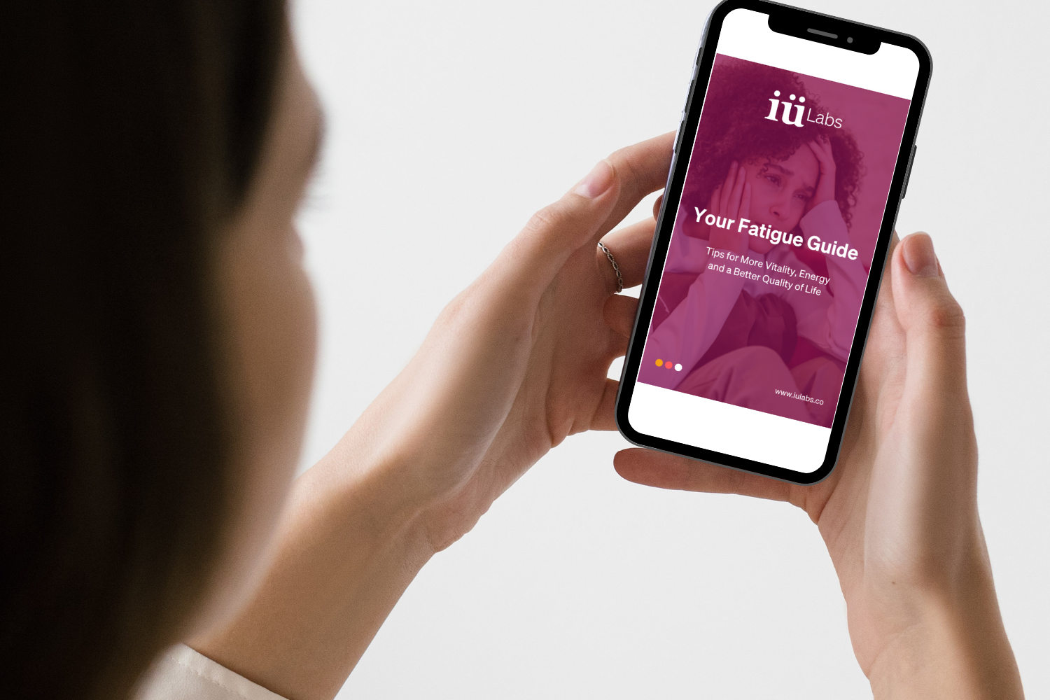 young woman holding phone with screen showing the iuLabs fatigue guide