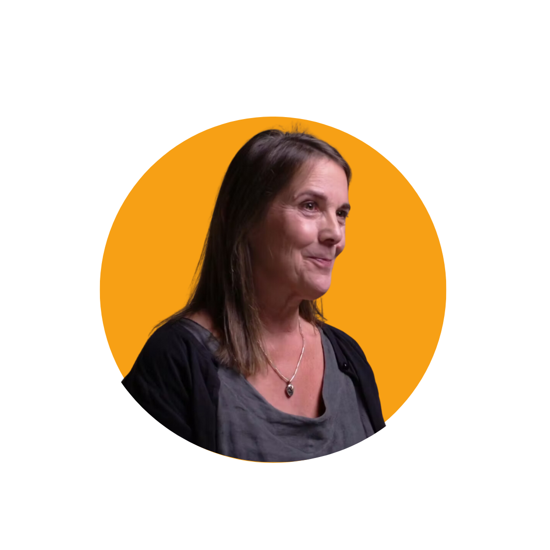 woman with brown hair smiling and looking to the side wearing a grey top and black cardigan with an orange background